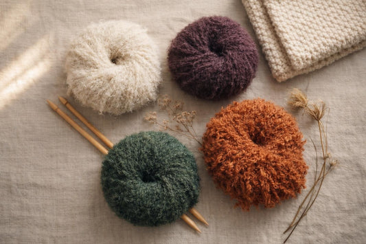 Flat-lay photograph of yarn skeins and knitting needles — FAIZA, FEBE et SHAZIA : trois nouveautés d’hiver
