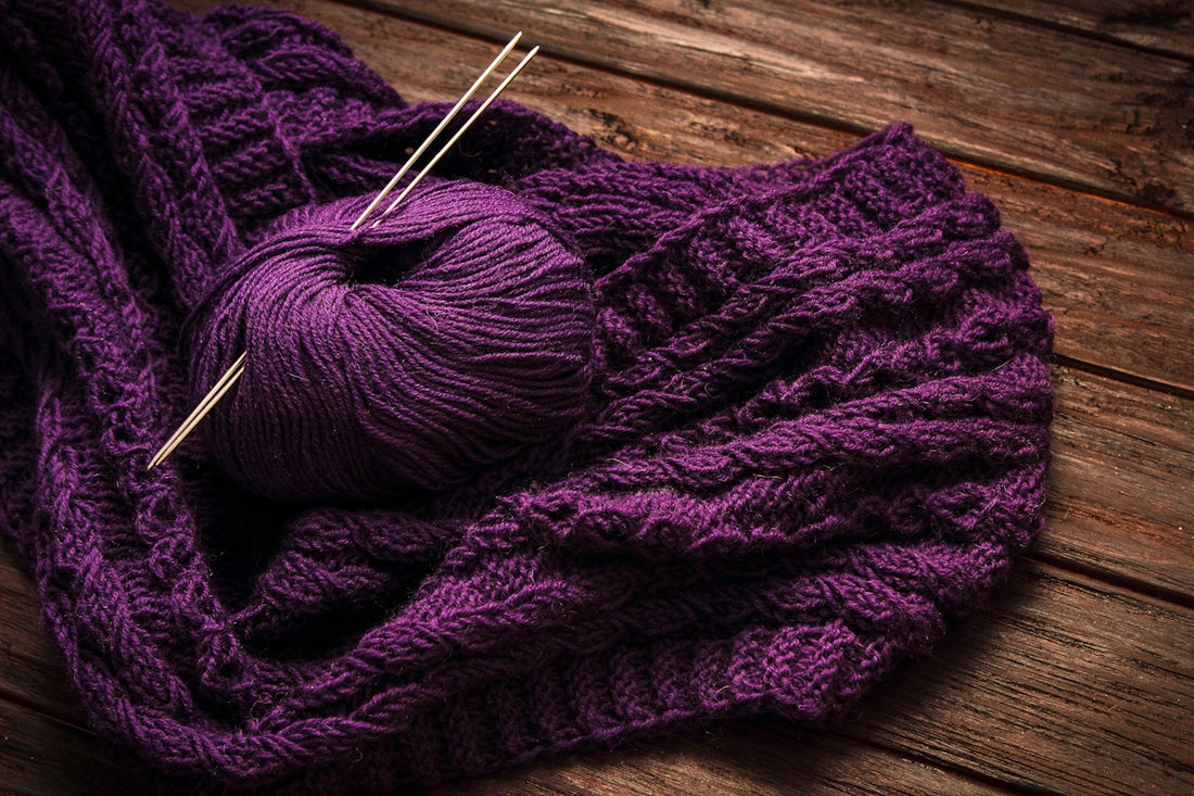 a ball of yarn sitting on top of a purple blanket