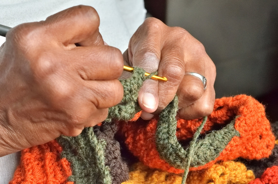 A person holding a crochet hook in their hands